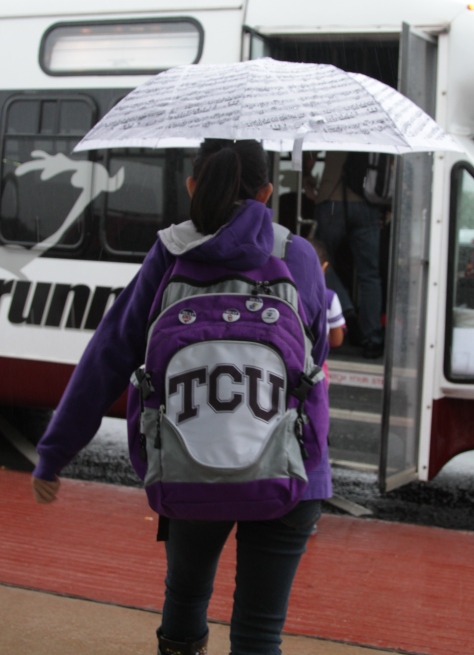 Samantha Calimbahin, a junior journalism major at Texas Christian University, dashes to the shuttle bus in the Sandage parking lot in Fort Worth, Texas on October 14, 2013.