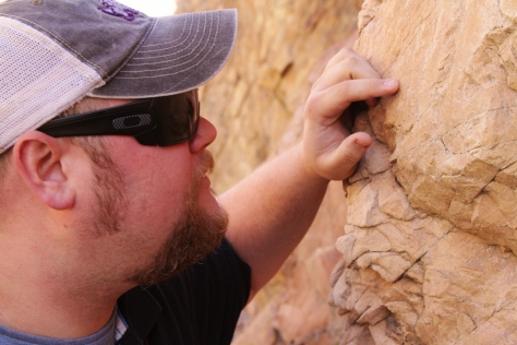 Texas Christian University student John Howard examines a section of rock exposed in a road cut along Interstate 80 outside of Salt Lake City Utah on October 23, 2013. (TCU/Bethany Peterson)